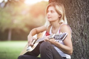 sing in tune like an a cappella singer - Singer Playing a Guitar - What Is the Point of Different Alternate Guitar Tunings