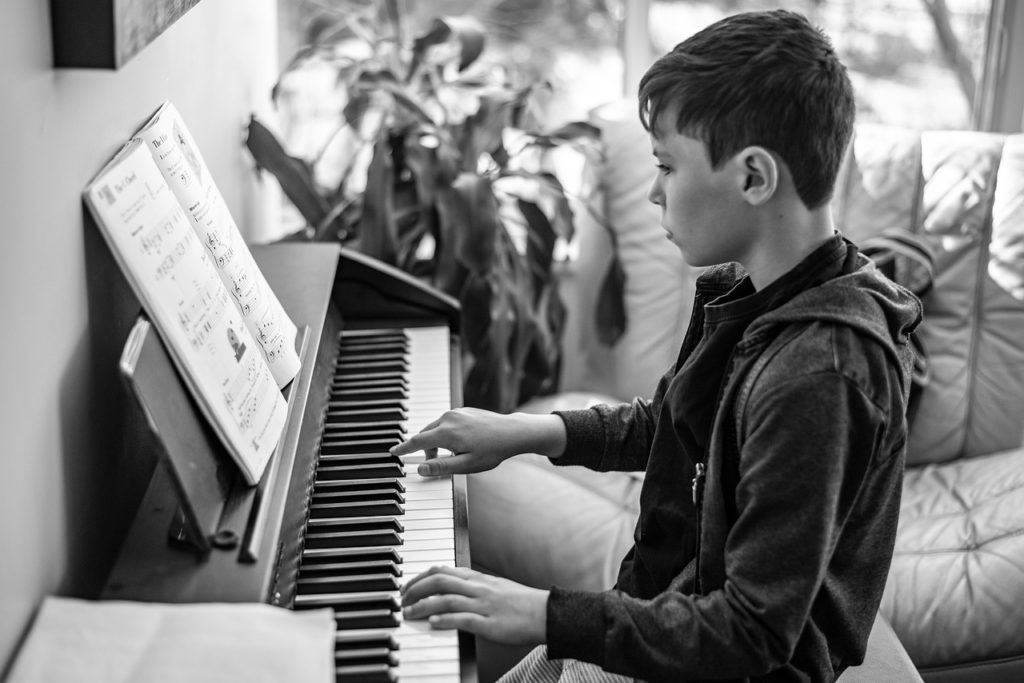 Autism - a boy playing the piano - How to Graduate from the Color Coded Music Notation