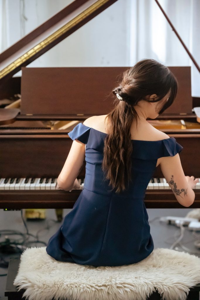 How does your brain learn to play the piano with two hands - Changing Keys in Your Songwriting - Young Woman Playing the Piano