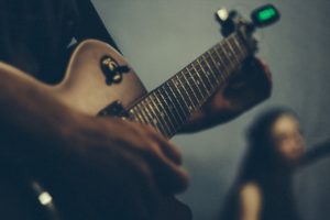 How to Use an Extremely Accurate Guitar Strobe Tuner to Make Your Guitar Sound Awesome - Guitarist Using a Tuner - What Common Mistakes Do People Make When Tuning Their Guitars - What’s the Difference Between Just Intonation and Equal Temperament - Why Does My Guitar Sound Off Tune