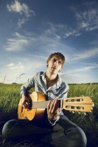 How Do I Make ANY Progress and Have Fun in Music Lessons Again - Guitarist in a Field