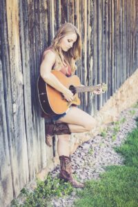 How to Play the Frustrating B Minor Guitar Chord - Woman Playing Guitar