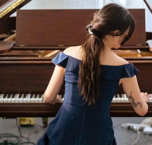 How does your brain learn to play the piano with two hands - Changing Keys in Your Songwriting - Young Woman Playing the Piano